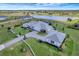 Wide aerial view of property featuring the main home, additional building, and beautiful landscaping and pond at 3574 Recurve Cir, Sarasota, FL 34240