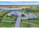 Aerial view of a luxurious home with a large lawn, lake, and a three-car garage at 3574 Recurve Cir, Sarasota, FL 34240