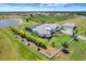 Aerial view of a luxurious estate, showcasing a well-manicured lawn, lakeside views, screened pool, and separate garage at 3574 Recurve Cir, Sarasota, FL 34240