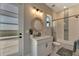 Bathroom features a granite vanity with a round mirror, a bathtub, and modern light fixtures at 3574 Recurve Cir, Sarasota, FL 34240