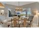 Elegant dining room showcasing a rustic wood table, stylish seating, and a large window overlooking the pool area at 3574 Recurve Cir, Sarasota, FL 34240