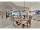 Sunlit dining room showcasing a rustic wood table, elegant seating, and access to outdoor living spaces at 3574 Recurve Cir, Sarasota, FL 34240