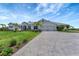Beautiful home exterior with a well-manicured lawn, palm trees, and a long driveway at 3574 Recurve Cir, Sarasota, FL 34240