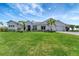 Beautiful white home with a well-manicured lawn, palm trees, and an attached three-car garage at 3574 Recurve Cir, Sarasota, FL 34240