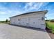 A detached three-car garage with white doors and stone accents on a paved driveway at 3574 Recurve Cir, Sarasota, FL 34240