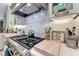 Close up of a stainless steel range and range hood with a subway tile backsplash and quartz countertop at 3574 Recurve Cir, Sarasota, FL 34240