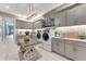 Spacious laundry room with gray cabinets, modern appliances, and decorative chandelier at 3574 Recurve Cir, Sarasota, FL 34240