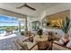 Covered patio with ceiling fans, comfortable seating, and views of the pool and golf course at 3574 Recurve Cir, Sarasota, FL 34240