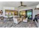 Covered outdoor patio featuring comfortable seating, ceiling fan, and large glass sliding doors to bring the outdoors in at 3574 Recurve Cir, Sarasota, FL 34240
