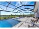 Large screened-in pool area features a spa, lounge chairs, and a scenic view at 3574 Recurve Cir, Sarasota, FL 34240