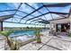 Backyard pool and patio featuring tropical plants, water features, and an enclosed patio with comfortable seating at 3574 Recurve Cir, Sarasota, FL 34240