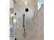 Modern shower featuring black fixtures and neutral-toned vertical tiles at 3574 Recurve Cir, Sarasota, FL 34240