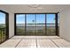 Enclosed balcony features tile floor, glass walls, fan and serene water views at 3630 Gulf Of Mexico Dr # 202, Longboat Key, FL 34228
