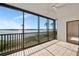 Enclosed porch features tile floor, ceiling fan and views of the waterway with palm trees at 3630 Gulf Of Mexico Dr # 202, Longboat Key, FL 34228