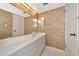 Bathroom with a wide sink and vanity, dual mirrors, cabinet storage, and textured wallpaper at 3630 Gulf Of Mexico Dr # 202, Longboat Key, FL 34228