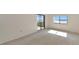 Bright bedroom with sliding glass doors to a balcony, carpet flooring, lake views and ample natural light at 3630 Gulf Of Mexico Dr # 202, Longboat Key, FL 34228