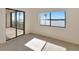A spacious bedroom with sliding glass doors to a balcony, carpet flooring, and ample natural light at 3630 Gulf Of Mexico Dr # 202, Longboat Key, FL 34228