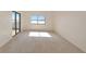 Bright bedroom with sliding glass doors to a balcony, carpet flooring and ample natural light at 3630 Gulf Of Mexico Dr # 202, Longboat Key, FL 34228