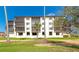 The condo building has a lush green lawn with palm trees, providing a tropical feel to the property at 3630 Gulf Of Mexico Dr # 202, Longboat Key, FL 34228