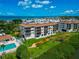 Exterior aerial of a condo building, pool, and landscaping near the ocean at 3630 Gulf Of Mexico Dr # 202, Longboat Key, FL 34228