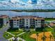 Exterior of a white condo building with balconies and manicured green spaces near the water at 3630 Gulf Of Mexico Dr # 202, Longboat Key, FL 34228