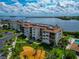 Waterfront condominiums with balconies overlook lush landscaping, water, and a pool at 3630 Gulf Of Mexico Dr # 202, Longboat Key, FL 34228