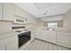 Well-lit kitchen offering a full suite of white appliances, tile flooring and generous cabinet space at 3630 Gulf Of Mexico Dr # 202, Longboat Key, FL 34228