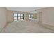 Spacious living room with carpet, mirrors, and a lanai with water views at 3630 Gulf Of Mexico Dr # 202, Longboat Key, FL 34228