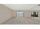Large living room with mirrors and lanai access at 3630 Gulf Of Mexico Dr # 202, Longboat Key, FL 34228