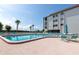 Community pool with a clear blue water surrounded by a brick patio and lounge chairs at 3630 Gulf Of Mexico Dr # 202, Longboat Key, FL 34228