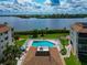 Exterior aerial showcasing a community pool with lounge chairs and waterfront views at 3630 Gulf Of Mexico Dr # 202, Longboat Key, FL 34228
