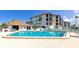 Large community pool with surrounding lounge area, palm trees, and a clubhouse at 3630 Gulf Of Mexico Dr # 202, Longboat Key, FL 34228