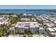 Aerial view of a condo complex with a pool, landscaping, waterfront views, and surrounding residences at 3806 Gulf Of Mexico Dr # C204, Longboat Key, FL 34228