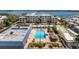 Aerial view of condo complex featuring a pool, shuffleboard, landscaping, and waterfront views at 3806 Gulf Of Mexico Dr # C204, Longboat Key, FL 34228