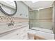 Bathroom featuring a shower with glass doors, vanity with countertop, and a decorative mirror at 3806 Gulf Of Mexico Dr # C204, Longboat Key, FL 34228
