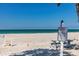 Beach view with private beach property sign, palm trees, and picnic table at 3806 Gulf Of Mexico Dr # C204, Longboat Key, FL 34228