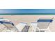 Inviting beach view with lounge chairs set up on the sandy shore and blue skies at 3806 Gulf Of Mexico Dr # C204, Longboat Key, FL 34228