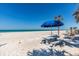 Relaxing beach scene featuring a picnic table and umbrella, perfect for a day by the sea at 3806 Gulf Of Mexico Dr # C204, Longboat Key, FL 34228