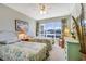 Bright bedroom featuring twin beds, a ceiling fan, and a large window with outside views at 3806 Gulf Of Mexico Dr # C204, Longboat Key, FL 34228