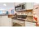 Modern kitchen featuring stainless steel appliances, granite counters, and white cabinetry at 3806 Gulf Of Mexico Dr # C204, Longboat Key, FL 34228