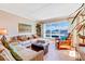 Bright living area with comfortable furniture and view of the city and blue skies from the large window at 3806 Gulf Of Mexico Dr # C204, Longboat Key, FL 34228