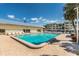 Large rectangular pool with lounge chairs and a clubhouse on a sunny day at 3806 Gulf Of Mexico Dr # C204, Longboat Key, FL 34228