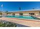Community pool with blue tiles and lounge chairs under the warm, sunny skies at 3806 Gulf Of Mexico Dr # C204, Longboat Key, FL 34228