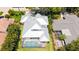 Aerial view of a home with a modern metal roof, screened-in pool and tropical landscaping at 3921 Maravic Pl, Sarasota, FL 34231