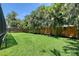 Spacious backyard featuring well-maintained lawn, mature palm trees, and a privacy fence at 3921 Maravic Pl, Sarasota, FL 34231