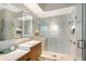 Modern bathroom featuring a walk-in shower with a glass door, LED mirror, and floating vanity at 3921 Maravic Pl, Sarasota, FL 34231