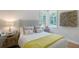 Comfortable bedroom featuring a corner window, stylish decor, hardwood floors and mirrored bedside tables at 3921 Maravic Pl, Sarasota, FL 34231