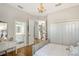 Bright bedroom featuring hardwood floors, decorative chandelier, and ensuite bathroom at 3921 Maravic Pl, Sarasota, FL 34231