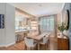 Dining area boasts a light-filled space with a modern light fixture, wood table and view to kitchen at 3921 Maravic Pl, Sarasota, FL 34231