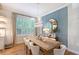 Charming dining room with a large wood table, blue accent wall, modern light fixture, and window at 3921 Maravic Pl, Sarasota, FL 34231